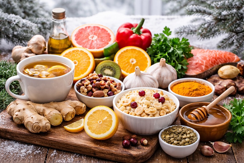 Zimowa dieta wspierająca odporność, zdrowe produkty spożywcze na stole, warzywa, owoce, herbata z imbirem i naturalne składniki w zimowej scenerii